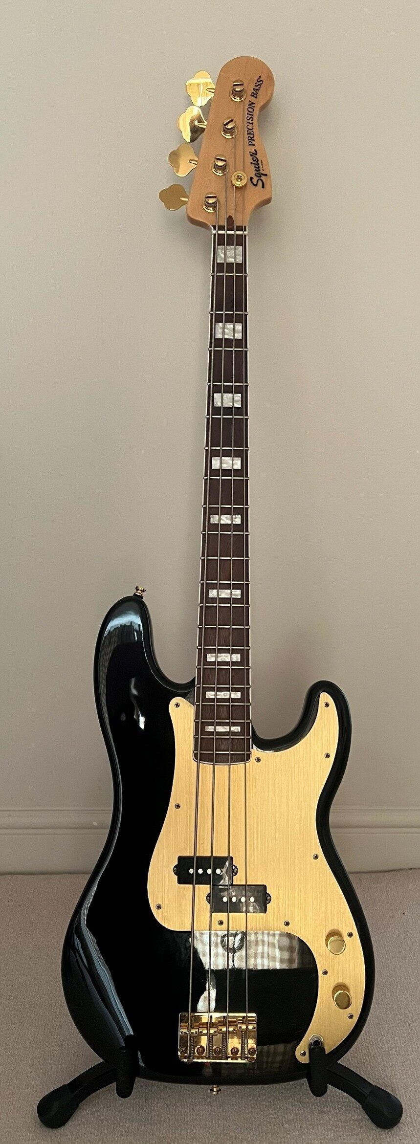 In‑room photo of Lottie’s Squier 40th Anniversary Precision Bass with gold hardware.